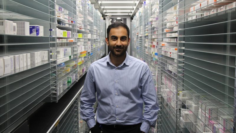Umair Hamid stands in a pharmacy aisle.